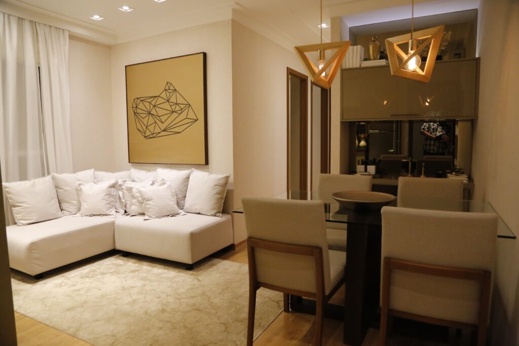 Sala de estar elegante com sofá seccional aconchegante e área de jantar moderna com iluminação geométrica.