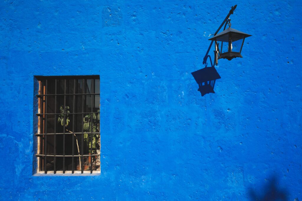 A Psicologia do Azul em uma Parede azul brilhante com sombra de janela e lanterna em Arequipa, Peru