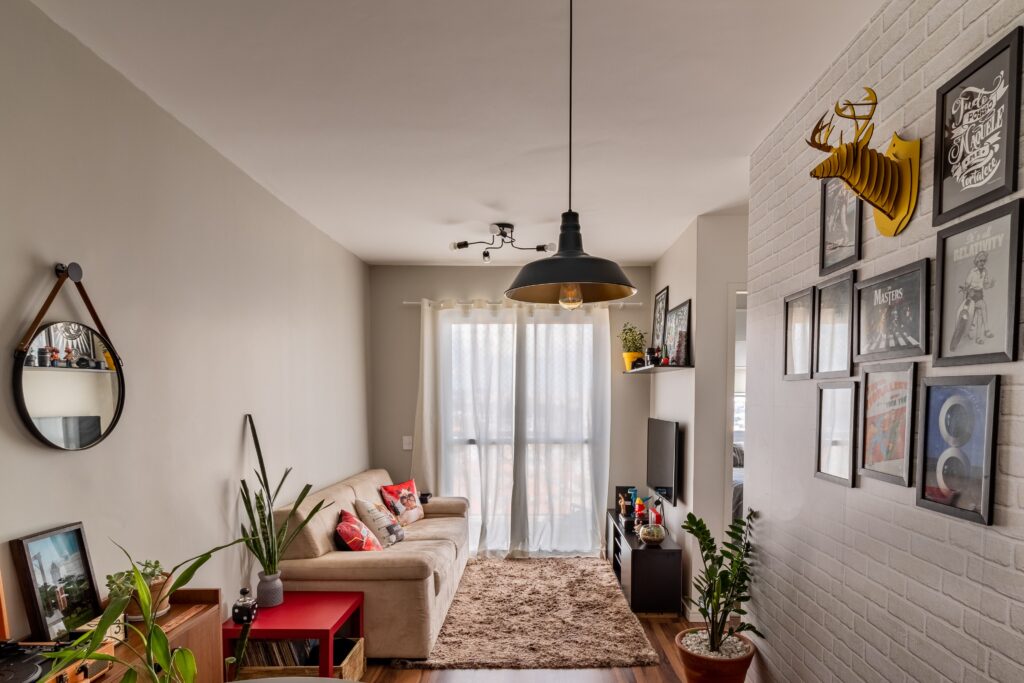 Uma sala de estar moderna e elegante com decoração artística nas paredes, sofá aconchegante, Iluminação direto no teto e plantas de interior.