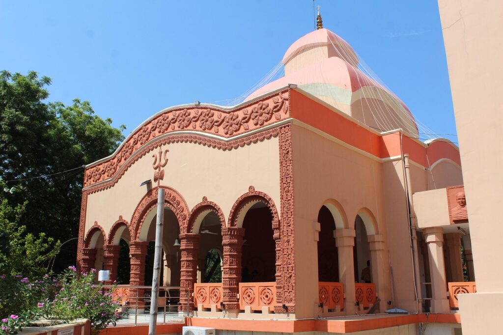 Templo hindu decorado para o festival de Durga Puja com arquitetura imponente e cúpula iluminada, onde a psicologia do laranja se manifesta em sua máxima vibração espiritual, simbolizando a iluminação, a energia da transformação e o sagrado através da luz.