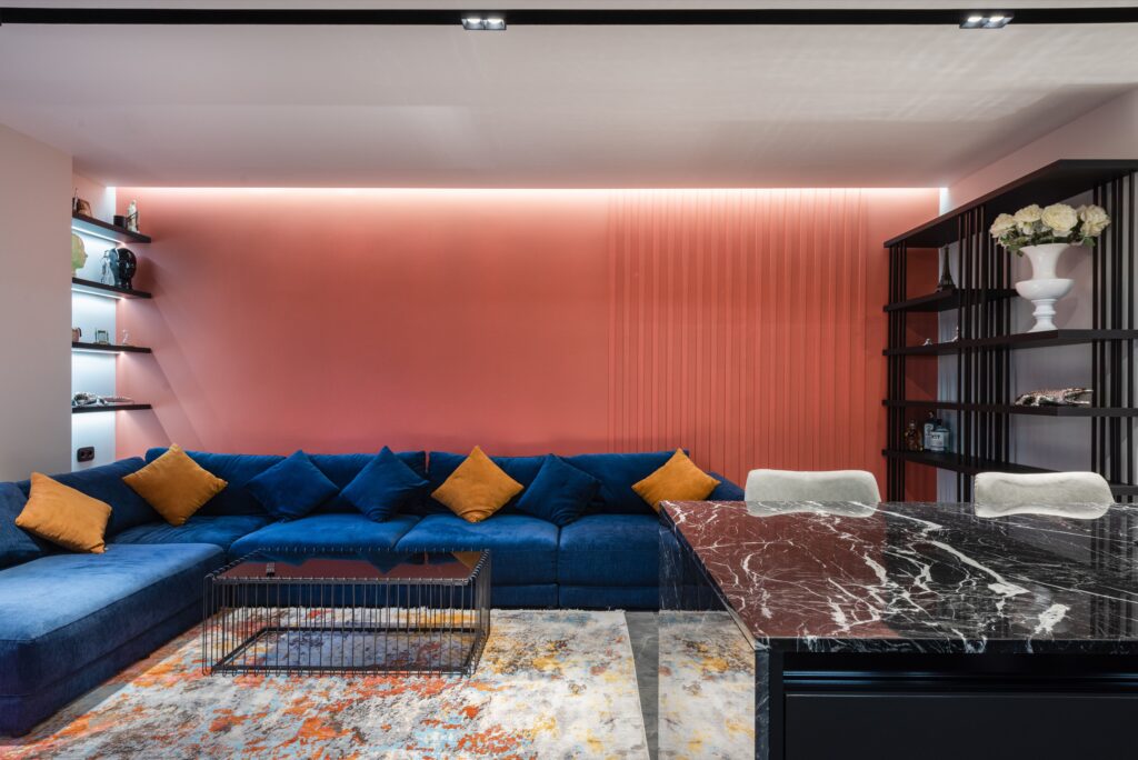 Interior de uma sala de estar contemporânea com sofá e mesa sobre um tapete com ornamentos abstratos, onde a psicologia do laranja se manifesta nos detalhes para criar uma âncora tátil e estabelecer um diálogo caloroso com o design minimalista.