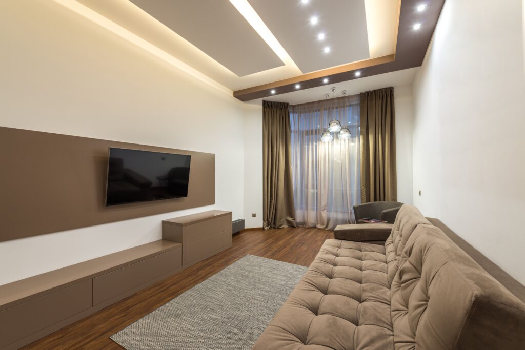 Spacious living room featuring marrom na decoração modern design with cozy furniture and warm lighting.
